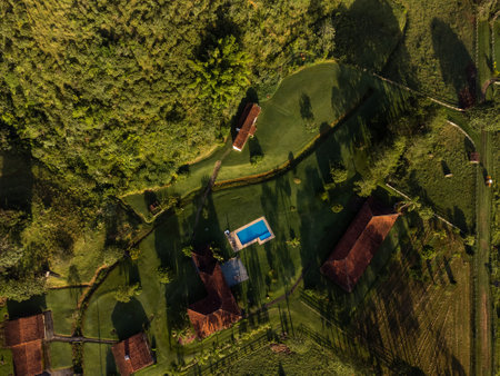 Aerial view of beautiful forest full of nature and pasture fields in TremembÃ© in Vale da ParaÃ­ba in SÃ£o Paulo. Mountains and hills in sunny day. Lots of green and tropical vegetation. Drone. Sunset.の写真素材