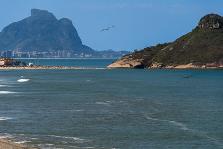 Macumba Beach and Recreio dos Bandeirantes in Rio de Janeiro, Brazil. Pedra do Pontal and Pedra da GÃ¡vea in the background. Beach on the west side of town. Sunny day and people on the beach.の写真素材