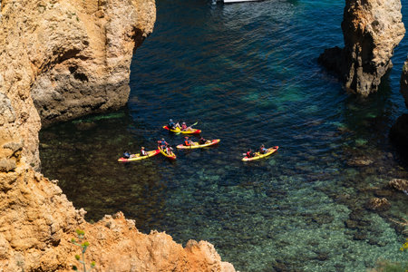 Ponta da Piedade near Lagos in Algarve, Portugal. Cliff rocks and tourist boat on sea. Dona Ana Beach, Students beach. Sunny day. Point of Pity.の写真素材