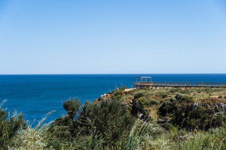 Ponta da Piedade near Lagos in Algarve, Portugal. Cliff rocks and tourist boat on sea. Dona Ana Beach, Students beach. Sunny day. Point of Pity.の写真素材