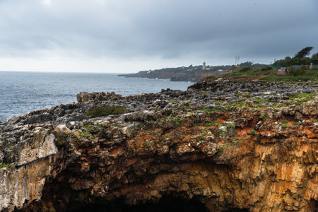 Boca do Inferno (Hell's Mouth) is a unique rock formation on the edge of the ocean in Cascais, Portugal. Cloudy day. Dramatic sea and skyの写真素材
