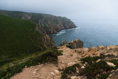 Coastline of Portugal, Cabo da Roca. Cape Roca in Sintra. The lighthouse in Cabo da Roca. Cliffs and rocks on the Atlantic ocean coast. Cloud day.の写真素材