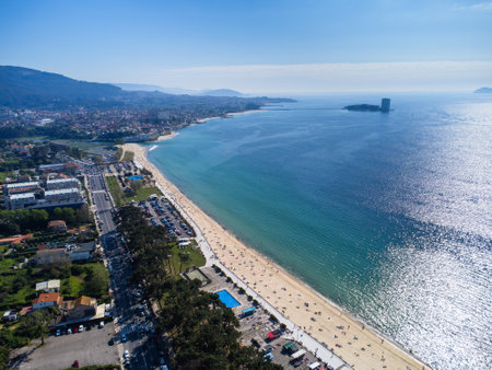 Aerial view of Playa de Samil, the main beach of Vigo in Galicia in northwest Spain. Sunny day, crystal clear blue sea. Houses, streets. Drone.の写真素材