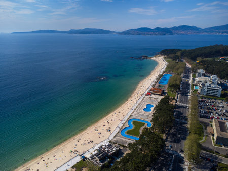 Aerial view of Playa de Samil, the main beach of Vigo in Galicia in northwest Spain. Sunny day, crystal clear blue sea. Houses, streets. Drone.の写真素材