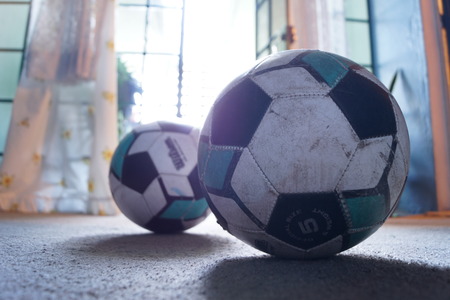 Two soccer balls in a house, illuminate by the sun of the morningの写真素材