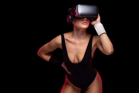 Beautiful active young sportive attractive caucasian athlete training wearing black leotard and hi tech futuristic glasses - Studio beauty shooting with sportive brunette model during workout routineの写真素材