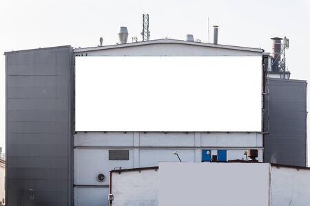 Blank white advertising billboard on the wall of the factory buildingの写真素材