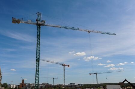 Many construction cranes on residential area