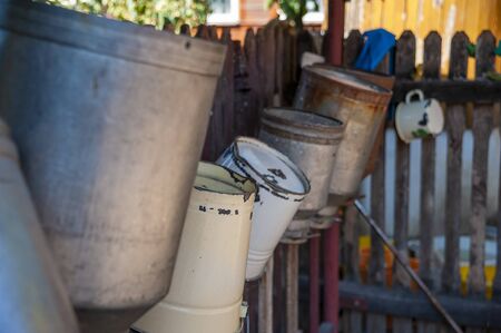 Vintage milk buckets drying on the fenceの写真素材