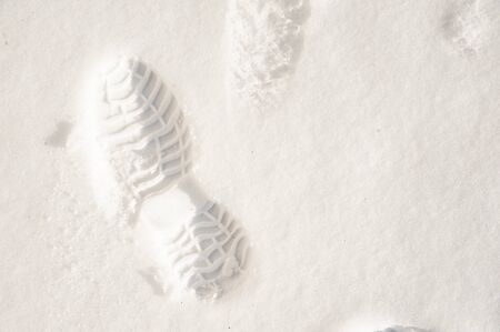 Footprint in fresh snow. Pattern of winter shoes sole.の写真素材