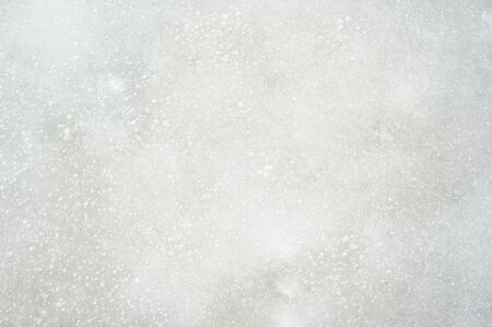 Closeup of the ice surface on a sunny day. Ice is rough with air bubbles and dentsの写真素材