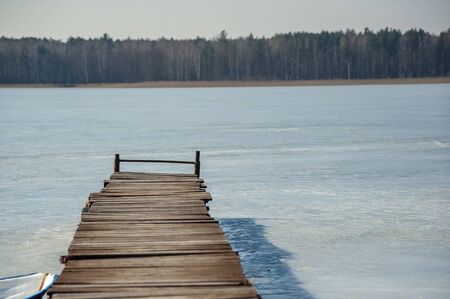 Closeup of the old pier on the frozen lake