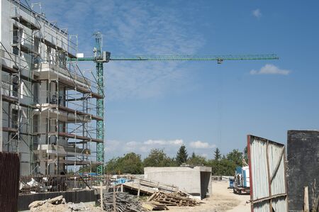 Crane and scaffolding on the construction area of new residential building.