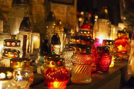 Candles burning at a cemetery. Polish tradition of commemorating deceased loved ones. 'All Saints Day' - November 1stの写真素材