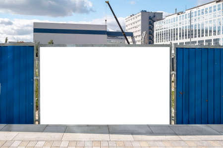Blank white advertising billboard on the fence of construction site