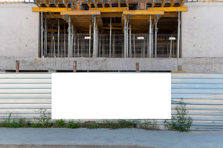 Blank white advertising banner on the construction site fence