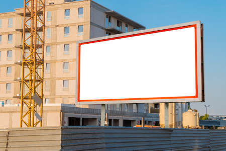 Blank white advertising billboard in front of the building under constructionの写真素材