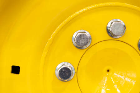 Close-up of yellow wheel rim with screwsの写真素材