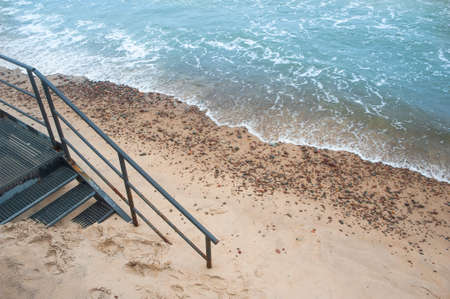 Steel stairs on a beach covered with sandの写真素材