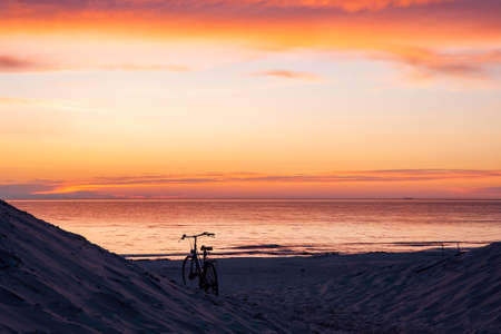 Bicycle on the beach at sunsetの写真素材