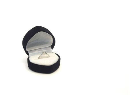 Engagement ring in heart-shaped box on white