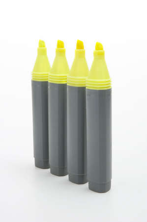 four yellow highlighter pens isolated on whiteの写真素材