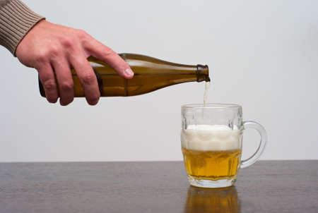 Filling a Dimpled Pint Glass of Beer from the Bottleの写真素材