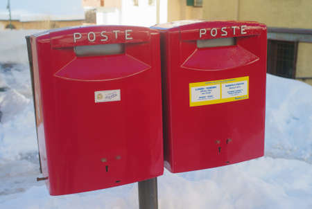 Cortina d' Ampezzo, Belluno, Italy - 2 February 2019: Two red post boxes of the Italian Postal Service called 'Poste italiane' in the city center of the famous skiing resort Cortina d' Ampezzo, Italy.のeditorial素材