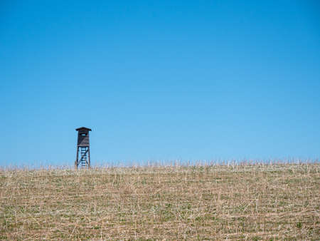 A Hunting Perch or High Seat in a Field with Dry Grass in a Lonely Rural Area in Austriaの写真素材