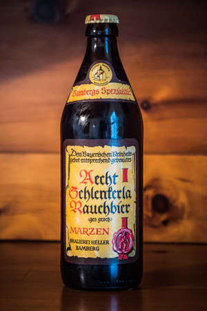 Bamberg, Germany - February 23 2020: A bottle of Bamberg Smoked Beer from the famous Schlenkerla Brewery in Bamberg, Bavaria, Germany on a wood background in portrait orientation.のeditorial素材
