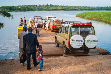 Paraa Ferry Terminal, Uganda - July 17 2011: Paraa or Parra Vehicle Ferry Crossing the Victoria Nile in Murchison Falls National Park, Uganda, Africa. People Boarding the Ferry.のeditorial素材