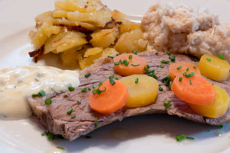 Viennese Prime Boiled Beef Tafelspitz with Traditional Sides of Chives Sauce, Viennese Potatoes, Bread Horseradish and Carrotsの写真素材