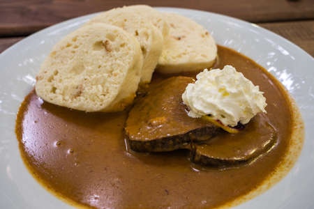 Czech Beef Tenderloin in Cream Sauce with Bread Dumplings called Svickova na Smetane a houskove knedliky on a white Plateの写真素材