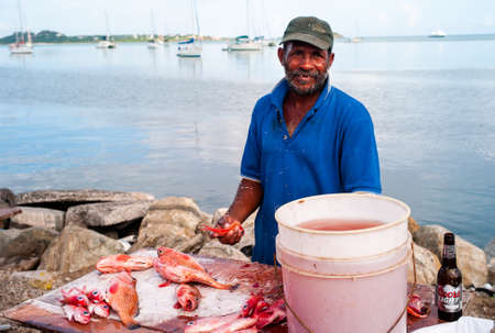 Marigot, Saint Martin - July 13 2013: Fish Monger or Cleaner Cleaning Fish at the Local Market...
