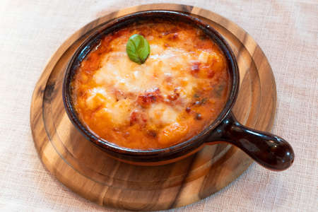 Gnocchi alla Sorrentina, Italian Potato Dumplings in Tomato Sauce, Gratinated With Mozzarella Cheese in a Terracotta Dishの写真素材