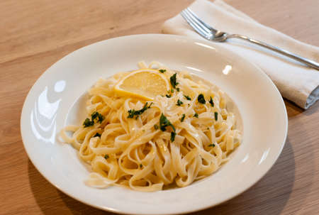 Italian Lemon Pasta or Tagliatelle al Limone on a White Plate with Parsleyの写真素材