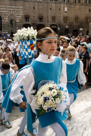 Siena, Tuscany, Italy - August 15 2022: Flower Girl of the Onda or Wave Contrada at the Cero Votivo Procession at the Palio di Siena in Tuscany, Italyのeditorial素材
