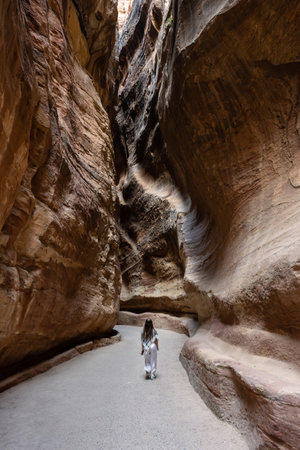 Petra, Jordan - October 27 2022: The Siq Gorge Entrance to the Nabatean City Petra with a Young Girl wearing a Keffiyeh Scarf.のeditorial素材