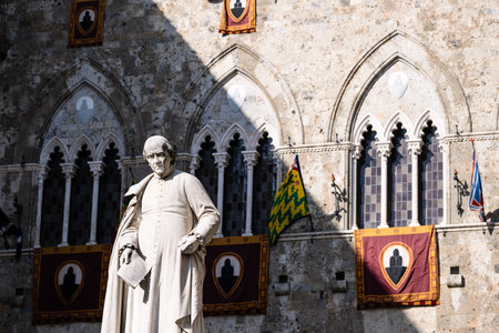 Siena, Italy - August 16 2022: Statue of Sallustio Bandini in Front of the Palazzo Salimbeni in Siena, Italy, made by Tito Sarrocchi in 1880.のeditorial素材