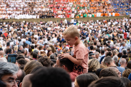 Siena, Italy - August 14 2022: Crowd of Spectators and Boy at the Palio di Siena in the Piazza del Campo.のeditorial素材