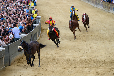 Siena, Italy - August 17 2022: Palio di Siena Public Horse Race with Empty or Riderless Horses Gallopping on the Piazza del Campo with Jockey or Fantino Scompiglio Jonatan Bartoletti riding for Chiocciola Contrada.のeditorial素材