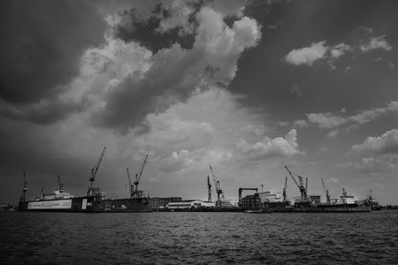 Hamburg, Germany - June 17 2023: Blohm und Voss Swimming Dock 11 on the Elbe River with Cranes in a Dramatic Black and White Urban Landscapeのeditorial素材