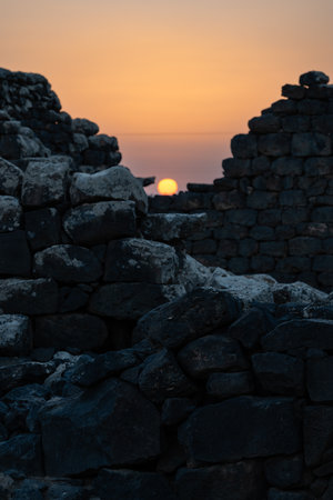 Umm El Jimal with the Orange Sun Setting Behind the Ancient Ruinsの写真素材