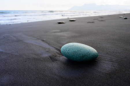 Green Stone on Penggajawa Beach with Black Sand on Flores Island, Indonesiaの写真素材
