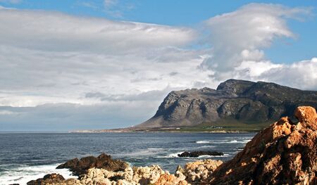 Mountains seen accross the bay  with rocks in foreground 