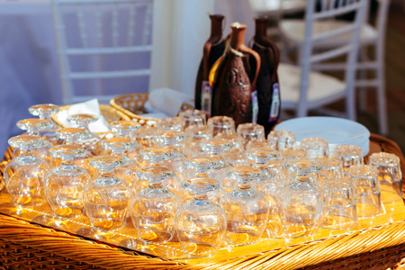 Close-up of empty glasses for brandy and whiskey, stemware on wicker tableの写真素材