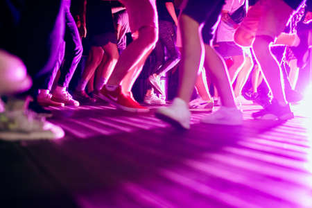 Crowd of people on dancefloor in a club. Legs, feet, sneakers at rave party.の写真素材
