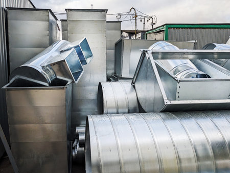 A close-up view of galvanized metal ventilation ducts used to transport ventilation throughout a large buildingの写真素材