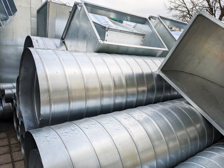 Close-up of ribbed metallic ventilation tubes in an industrial setting. Galvanized Ventilation Pipes.の写真素材