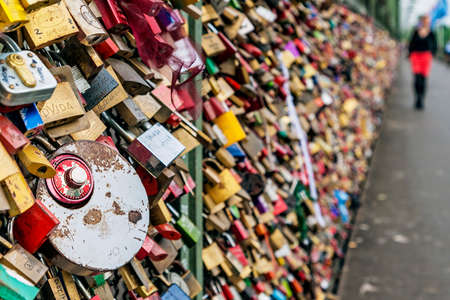 Lovelocks at the Hohenzollern Bridge in Cologne, Germany with blurred siluette of woman in distanceのeditorial素材